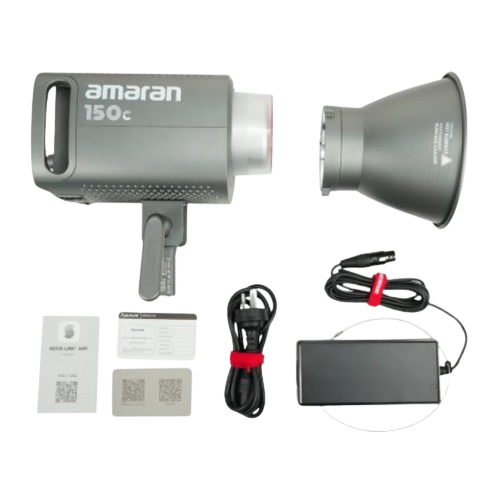 Projecteur LED Amaran 150c accompagné de ses accessoires incluant un adaptateur secteur, des câbles et un Hyper Reflector